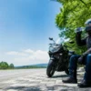 真夏の休憩スペースでバイクを停めて水分補給するライダー