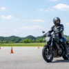 管理された舗装コースでパイロンの間を低速走行するライダー